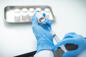 A female doctor holds a bottle and syringe of Covid-19 vaccine